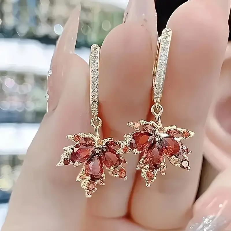 Boucles d'oreilles dorées en forme de feuille avec zircon
