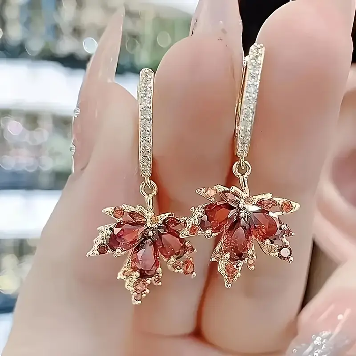 Boucles d'oreilles dorées en forme de feuille avec zircon
