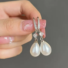 Boucles d'oreilles brillantes avec des perles pendantes