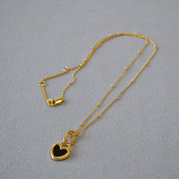 Collier avec pendentif en forme de cœur noir et blanc en or