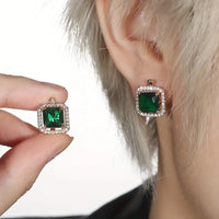 Boucles d'oreilles dorées avec zircon vert carré