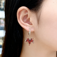 Boucles d'oreilles dorées en forme de feuille avec zircon