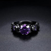 Bague vintage ronde noire avec une pierre précieuse violette
