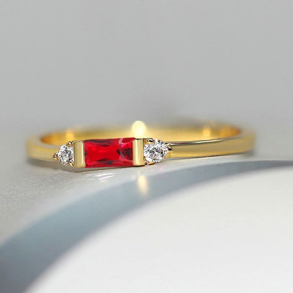 Pierre centrale rouge dorée et bague brillante