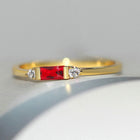 Pierre centrale rouge dorée et bague brillante