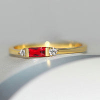 Pierre centrale rouge dorée et bague brillante