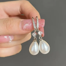 Boucles d'oreilles brillantes avec des perles pendantes